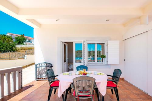 una sala da pranzo con tavolo e sedie sul balcone di Apartment Bilice beach a Bilice (Bilizze)