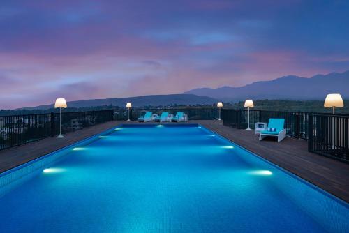 a swimming pool on the roof of a building at Hyatt Centric Rajpur Road Dehradun in Dehradun