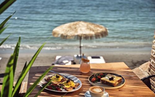 a table with two plates of food on the beach at Sanpiero Island in Zakynthos Town