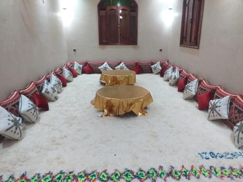 Habitación con 2 mesas y almohadas en el suelo en Auberge Dar Laazouzi, 