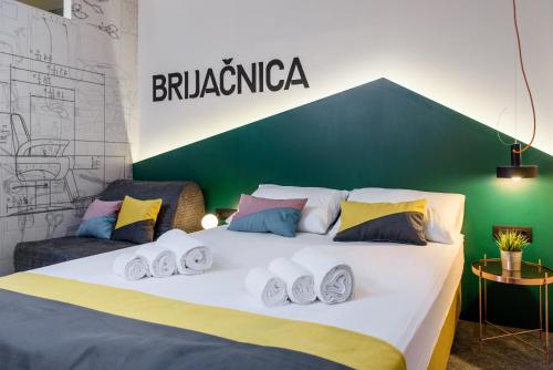 a bedroom with a large white bed with colorful pillows at Stay Swanky Bed & Breakfast in Zagreb