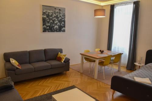 un soggiorno con divano e tavolo di Furmint & Juhfark Apartmanok a Veszprém