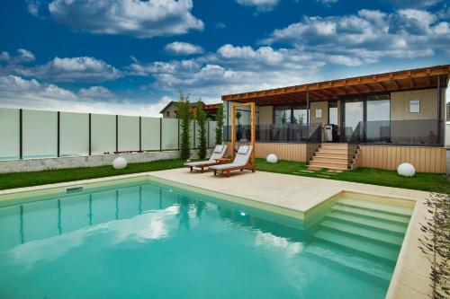 a swimming pool in front of a house at Peninsula Luxury & Spa in Năvodari