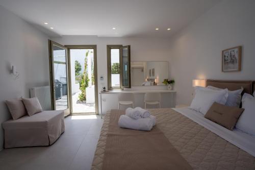 Paros Breeze Luxury Villa في دريوس: غرفة نوم عليها سرير وفوط
