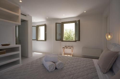 a white room with a bed and a window at Paros Breeze Luxury Villa in Drios