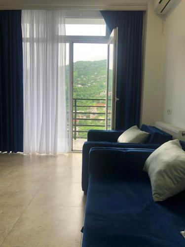 a living room with a couch and a large window at Blue Apartment in Gonio