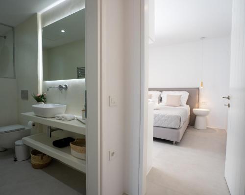 a white bathroom with a bed and a sink at Paros Breeze Luxury Villa in Drios