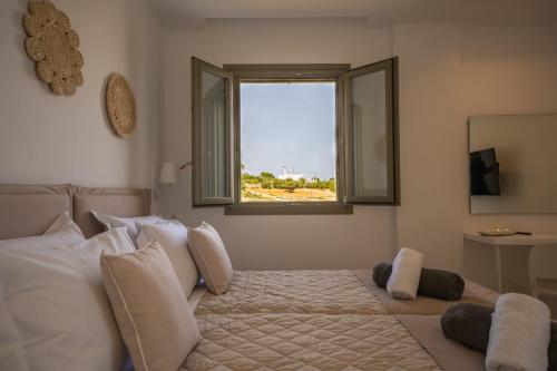 a bedroom with a large bed with a window at Paros Breeze Luxury Villa in Drios