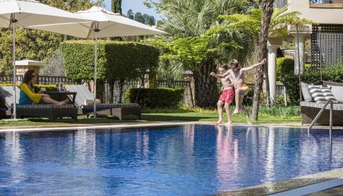 two young boys playing in a swimming pool at Four Seasons Hotel The Westcliff in Johannesburg