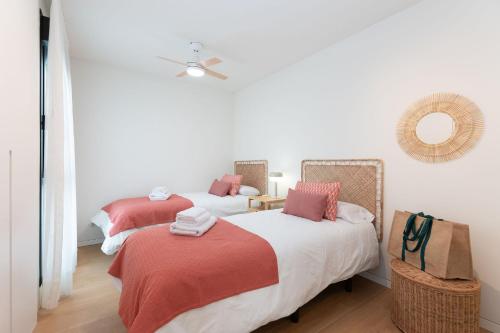 two beds with red and white sheets in a room at Apartamento Roca Paraíso Agaete vistas y jardín in Agaete
