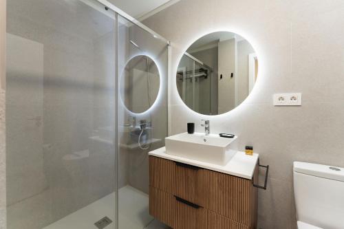a bathroom with a sink and a shower with a mirror at Apartamento Roca Paraíso Agaete vistas y jardín in Agaete