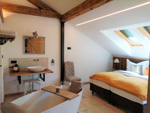 1 dormitorio con cama, lavabo y bañera en Roiderhof Irrsee, en Oberhofen am Irrsee