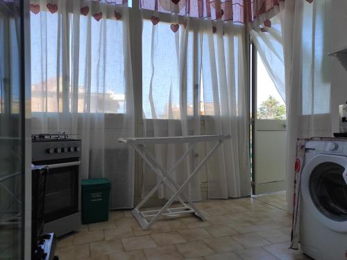 uma lavandaria com uma máquina de lavar roupa e uma janela em La casa di Anna em Villabate
