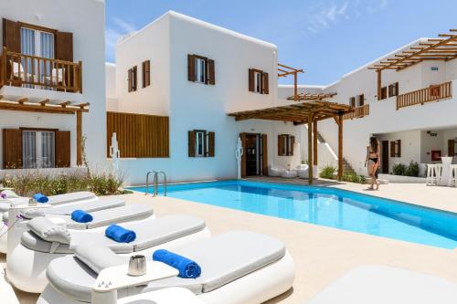 a villa with a swimming pool and lounge chairs at Mykonaki Hotel in Ano Mera