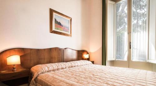 Un dormitorio con una cama grande y una ventana en Villa San Domenico en Castiglioncello