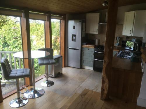 a kitchen with a table and chairs in a room at Chestnut,1 bedroom loft apartment with wood burner in Cardigan
