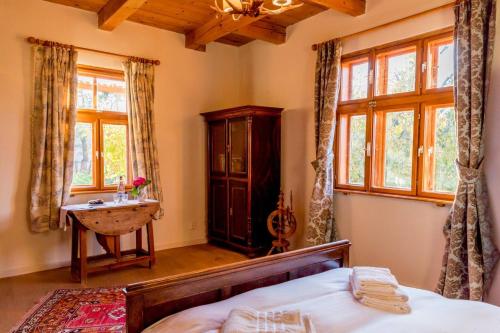 1 dormitorio con cama, lavabo y ventanas en Jotaferien Transylvanian Cottage with Fireplace, 