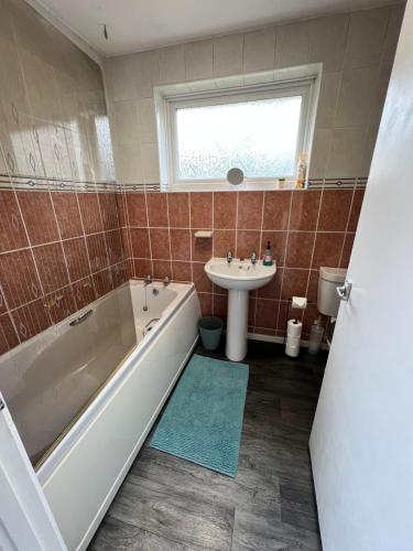 a bathroom with a tub and a sink at Impeccable 3 bed House in Northampton-perfect for families, contractors, insurance in Northampton