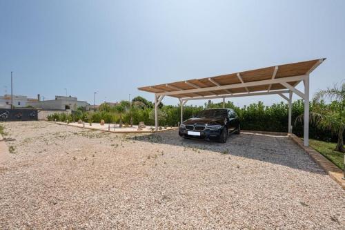 a car parked under a pavilion in a gravel driveway at L’Incanto in Corsano