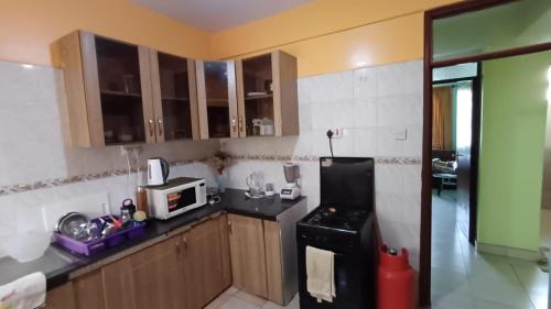 a kitchen with a black refrigerator and a microwave at Nakuru Lovely 2bedroom Master ensuite in Nakuru