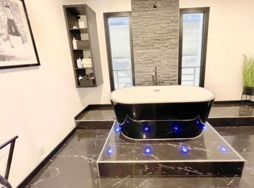 ein Badezimmer mit einer Badewanne auf einem Marmorboden in der Unterkunft Villa proche Disneyland paris 5 chambres 