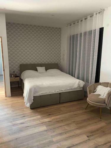 une chambre avec un grand lit et une chaise dans l'établissement Villa proche Disneyland paris 5 chambres, à Dhuisy
