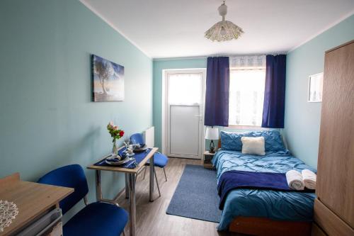 een kleine kamer met een bed, een tafel en een bureau bij noclegi u zabki in Ełk