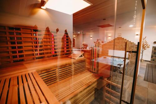 a room with a wooden bench and a glass wall at Maas en Waal Wellness & Suites in Dreumel