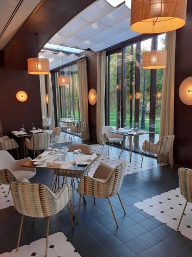 a restaurant with tables and chairs and large windows at Parador de Cangas de Onís in Villanueva de Cangas de Onís