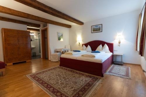 a bedroom with a large bed and a bathroom at Hotel Pension Kandolf in Tamsweg