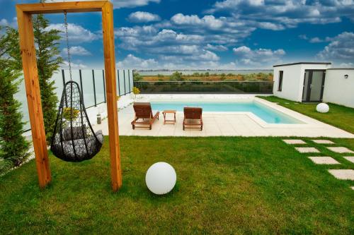 a yard with a swing and a swimming pool at Peninsula Luxury & Spa in Năvodari