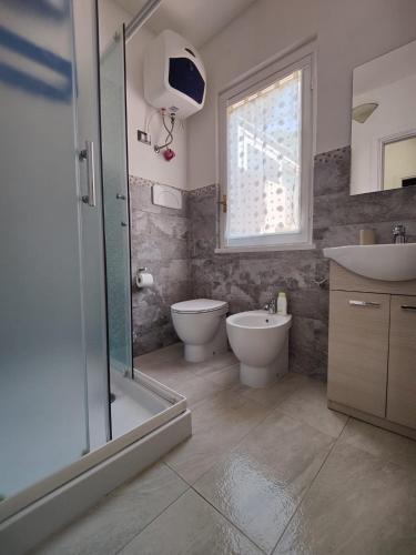a bathroom with a shower and a toilet and a sink at Casa Luna in Torre delle Stelle