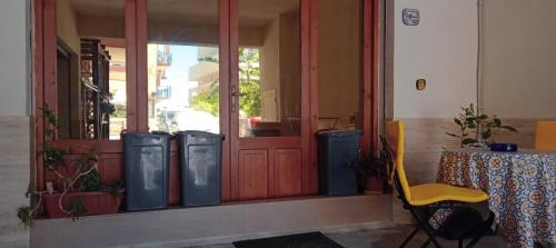 una stanza con tre bidoni della spazzatura davanti a una porta di Appartamento Seflonia a Cefalù