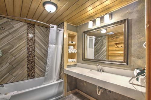 bagno con vasca, lavandino e specchio di Hibernation Station a West Yellowstone