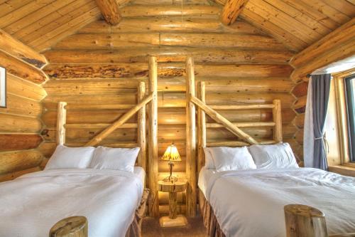 Duas camas individuais num quarto de madeira em Hibernation Station em West Yellowstone