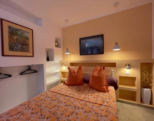 - une chambre dotée d'un lit avec des oreillers orange dans l'établissement Villa Campana - Sartène, à Sartène