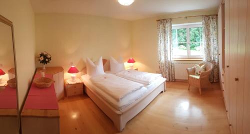 a bedroom with a large white bed and a window at Wunderschöne Ferienwohnung mit Seeblick in Zell am Moos