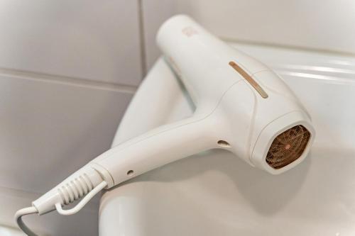 a white hair dryer on the side of a toilet at im Oberdorf in Achern