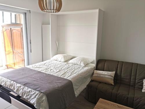 une chambre avec un lit et un canapé dans l'établissement Le Ptit Chaumois - 4 personnes, à Les Sables-dʼOlonne