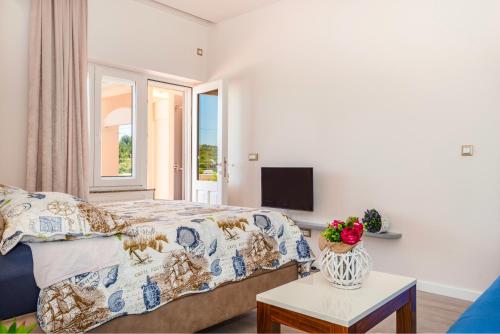 um quarto com uma cama, um sofá e uma televisão em Apartment Bilice beach em Bilice