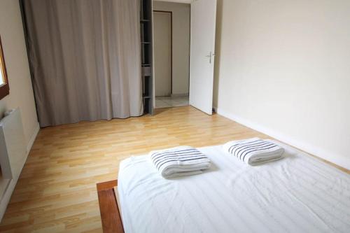 duas toalhas numa cama branca num quarto em Le petit Monlogis - Calme - Wi-Fi em Angoulême