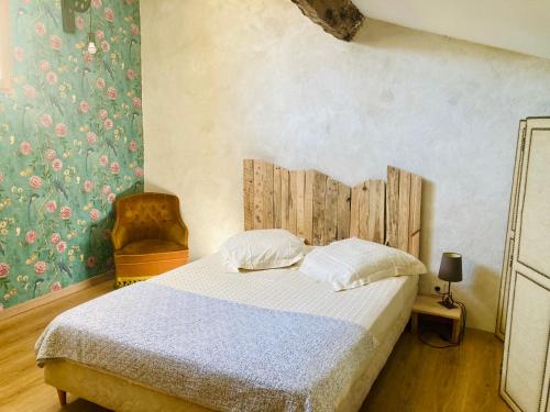 1 dormitorio con 1 cama y 1 silla en Chambres et gîte en Cévennes, en Cros