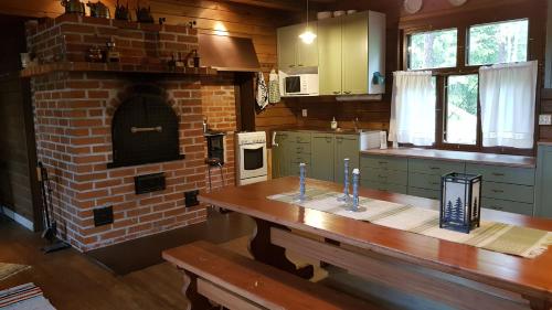 TuorilaにあるNikolain tupa, vanha hirsitaloのキッチン(木製テーブル付) 煉瓦窯