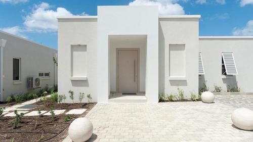 a white house with a door in a courtyard at Unforgettable 3BR Luxury Villa at Porter's Place in Saint James