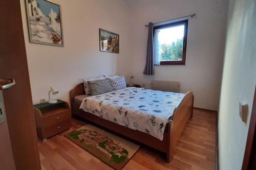 a small bedroom with a bed and a window at Quiet & Lovely Apartment-Ičići in Ičići