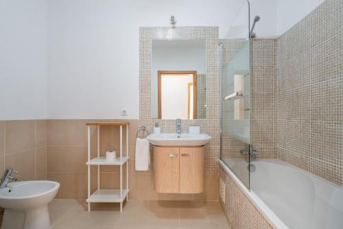 Delightful Cabanas 2 Bedroom apartment في كاباناس دي تافيرا: حمام مع حوض وحوض استحمام ومرحاض