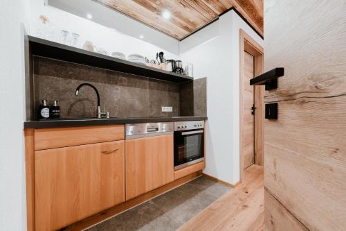 a kitchen with wooden cabinets and a sink at Apart GuetGeanLossn in Längenfeld