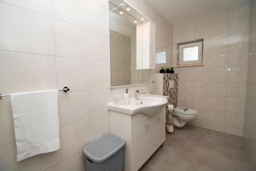 uma casa de banho branca com um lavatório e um WC em Villa La Perla Pula,Kroatien em Pula