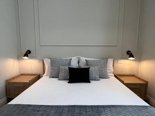 a bedroom with a large white bed with two lights at Cindy Rooms in Termoli