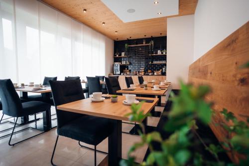 a restaurant with wooden tables and chairs and a bar at Pur-INN das Gästehaus in Purbach am Neusiedlersee